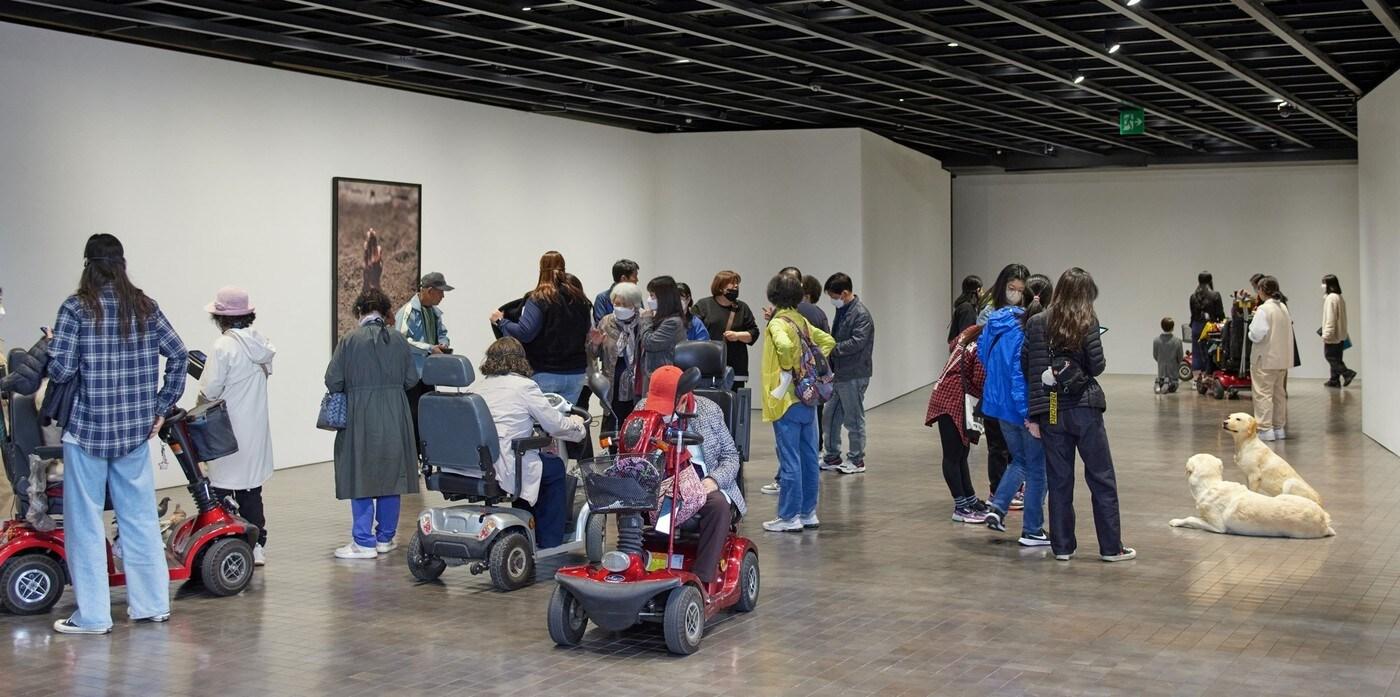 본문 이미지 -   리움미술관의 장애인 초청 행사에 참여한 참가자들이 마우리치오 카텔란의 작품을 감상하고 있다. (리움미술관 제공)