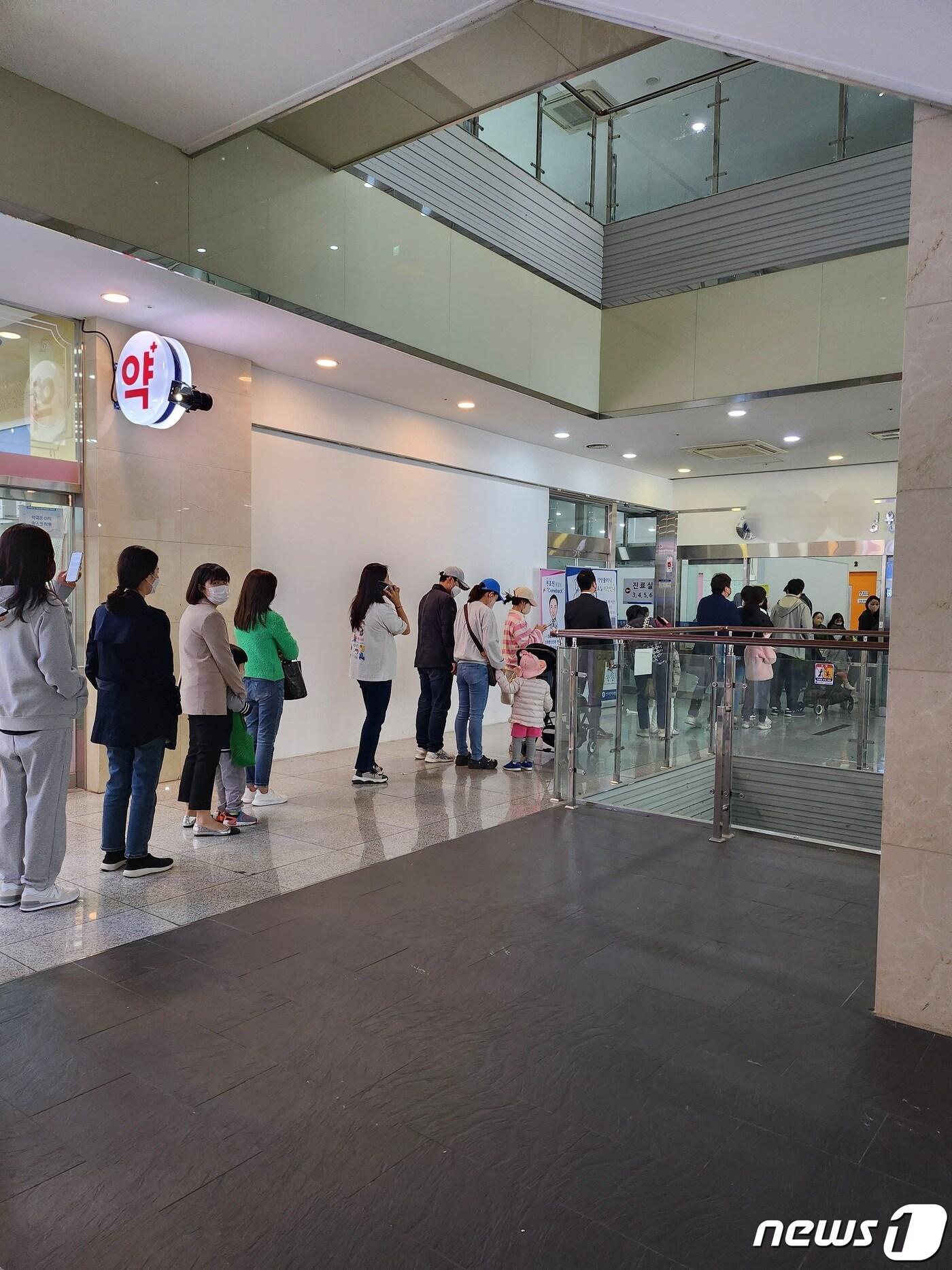 본문 이미지 - 18일 경기 화성시 동탄의 한 아동병원. 오후 진료를 보기 위한 접수줄이 길게 늘어서 있다.