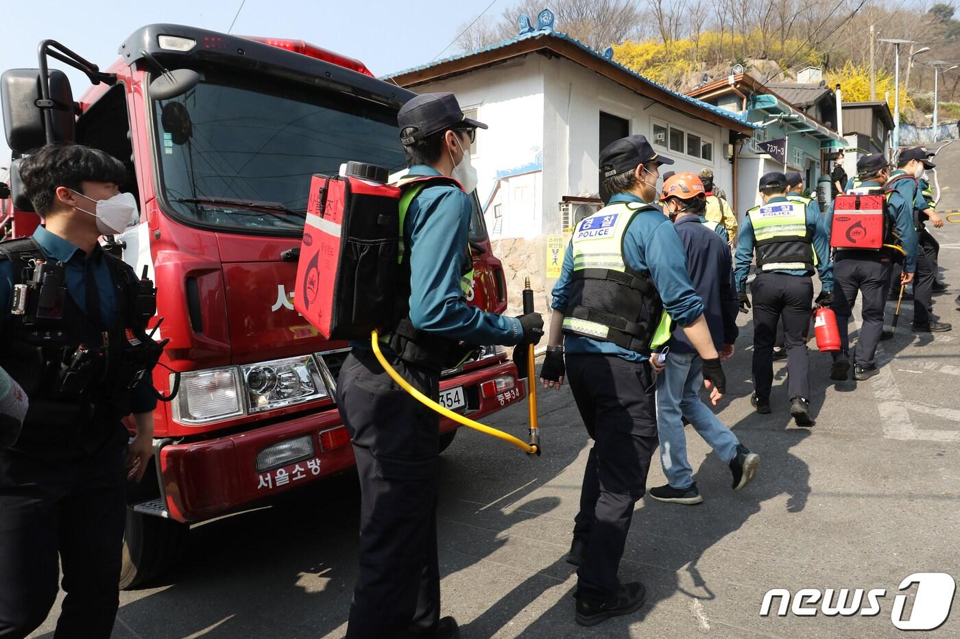 본문 이미지 - 서울 서대문구 홍제동 개미마을 진입로를 통해 소화 장비를 갖춘 경찰들이 인왕산 산불현장으로 투입되고 있다(사진은 기사 내용과 무관함) / 뉴스1 ⓒ News1 2023.4.2/뉴스1 ⓒ News1 민경석 기자