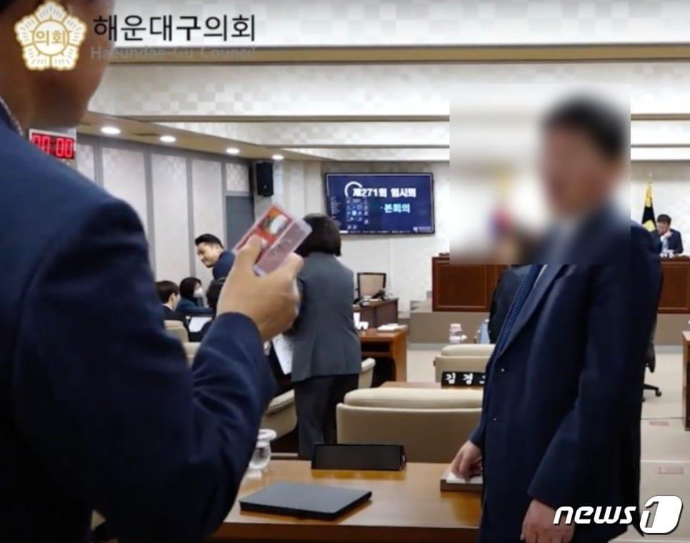 본문 이미지 - 지난 18일 부산 해운대구의회 제271회 임시회에서 김성수 해운대구청장이 화투를 손에 들고 본회의장에 입장했다. (해운대구의회 유튜브 캡처)