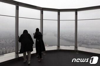 본문 이미지 - 절기상 곡우(穀雨)인 20일 오후 서울 송파구 롯데월드타워 전망대 '서울스카이'를 찾은 시민들이 구름 낀 한강 일대를 보고 있다. 2023.4.20/뉴스1 ⓒ News1 구윤성 기자