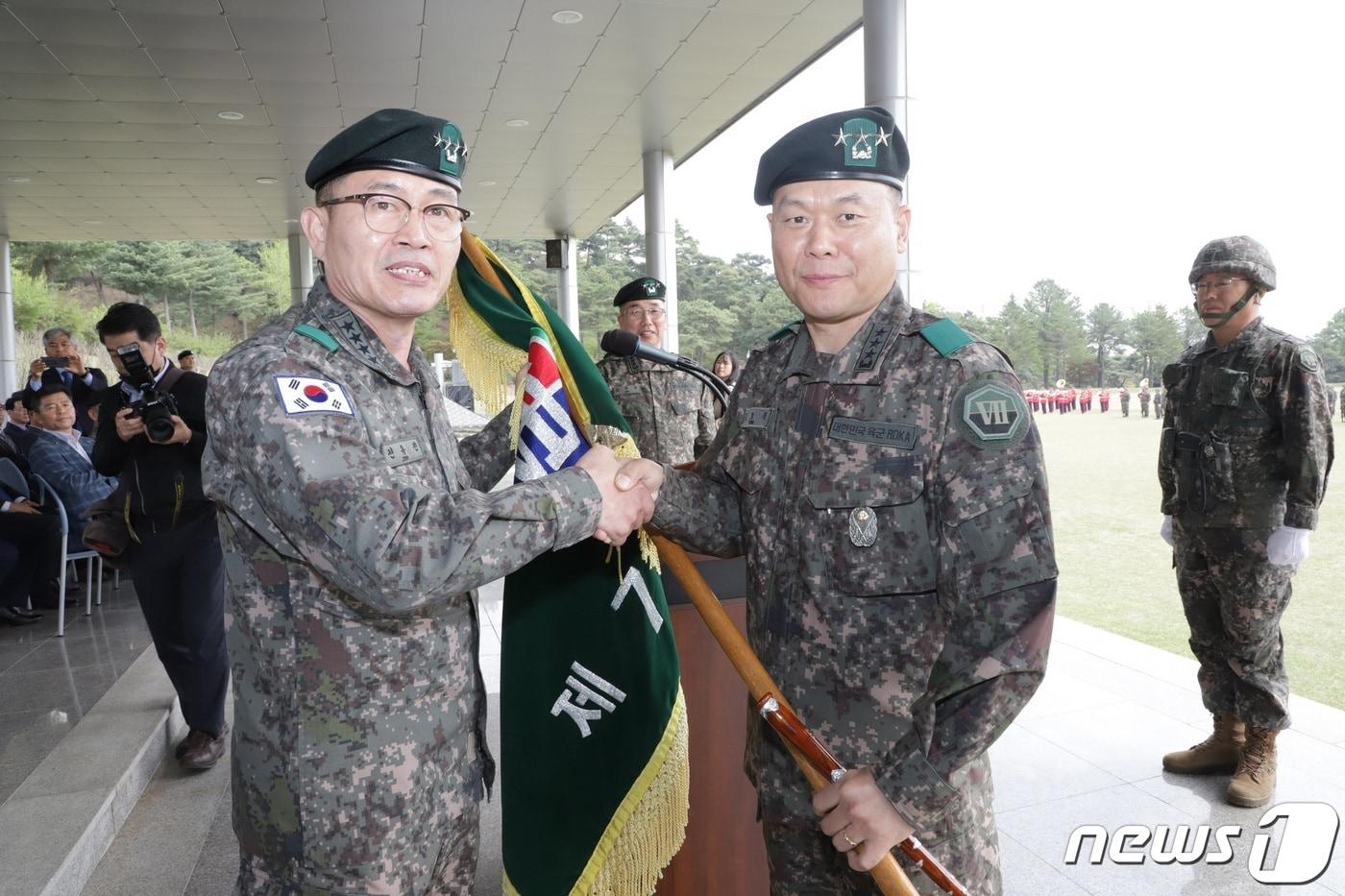 본문 이미지 - 전동진 지상작전사령관(왼쪽)이 김호복 신임 7기동군단장에게 부대기를 이양하고 있다.(육군 7기동군단 제공) 