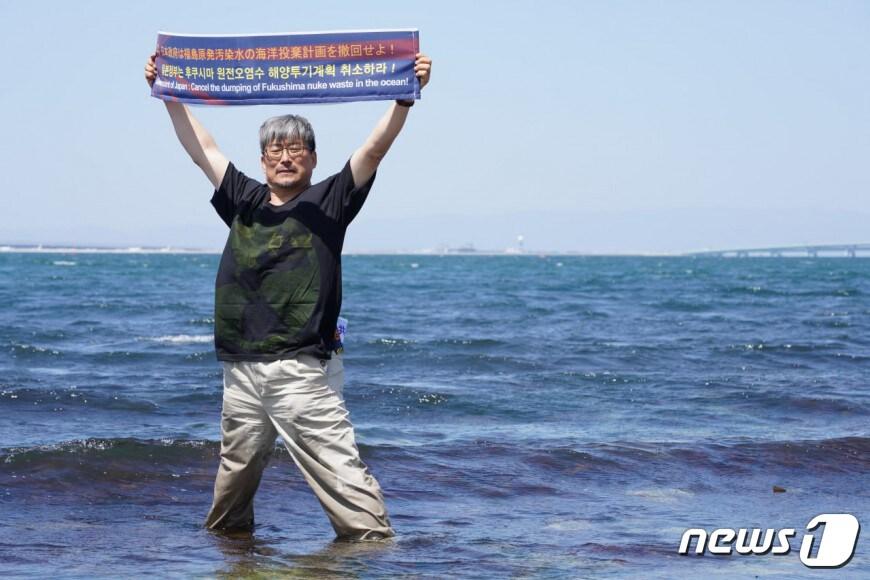 본문 이미지 - 환경운동연합 바다위원회를 비롯한 한일 시민단체 활동가들이 24일 일본 경제산업성과 도쿄전력 앞에서 각각 기자회견을 열고 후쿠시마 원전 오염수 방류 계획 철회를 촉구하는 항의서한을 전달했다. 사진은 일본 바다에서 후쿠시마 원전오염수 해양투기 반대 메시지를 들고 있는 환경운동연합 바다위원회 최예용 부위원장. (환경보건시민센터 제공) 2023.4.24/뉴스1