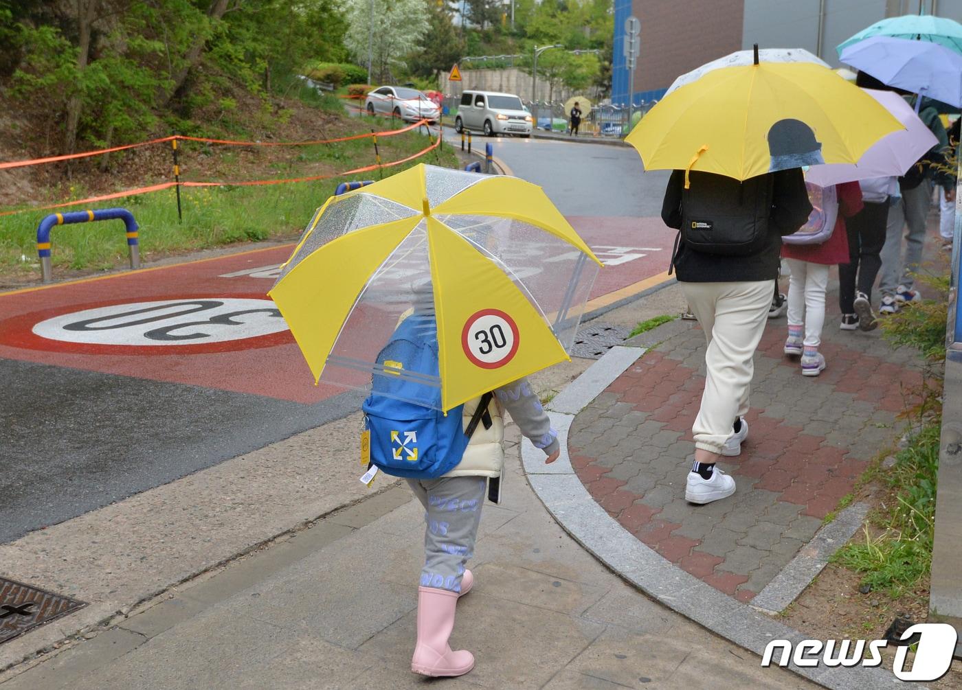 본문 이미지 - 봄비가 내렸던 지난 4월25일 오전 경북 포항시 북구에 있는 초등학교 인근에서 스쿨존 운행 속도가 찍힌 우산을 쓴 학생이 등굣길 발걸음을 재촉하고 있다.2023.4.25/뉴스1 ⓒ News1 최창호 기자