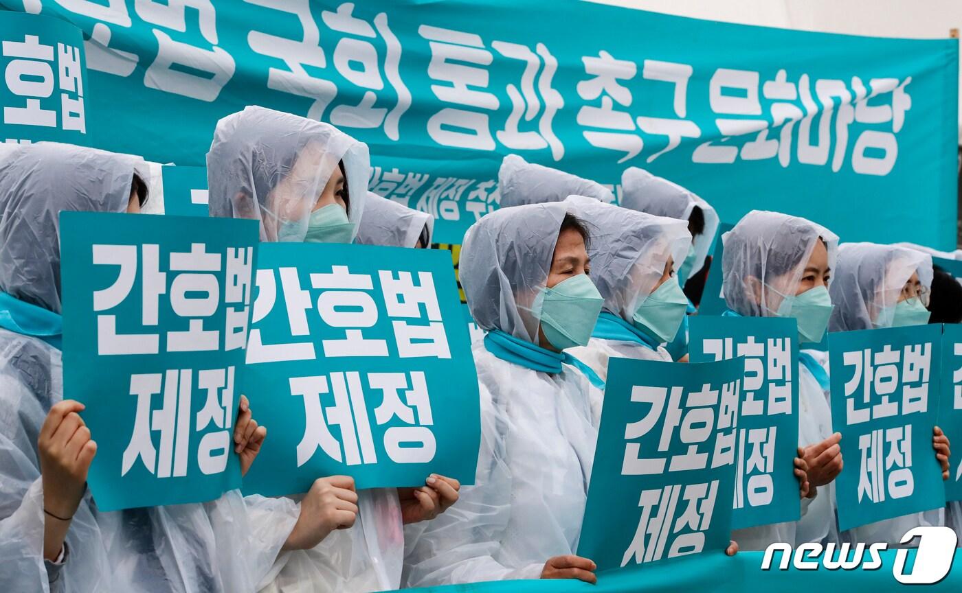 본문 이미지 - 대한간호협회와 시민단체 회원들이 25일 서울 영등포구 국회 앞에서 열린 간호법 국회 통과 촉구 문화마당에서 '간호법 제정'이 적힌 피켓을 들어 보이고 있다. 2023.4.25/뉴스1 ⓒ News1 DB