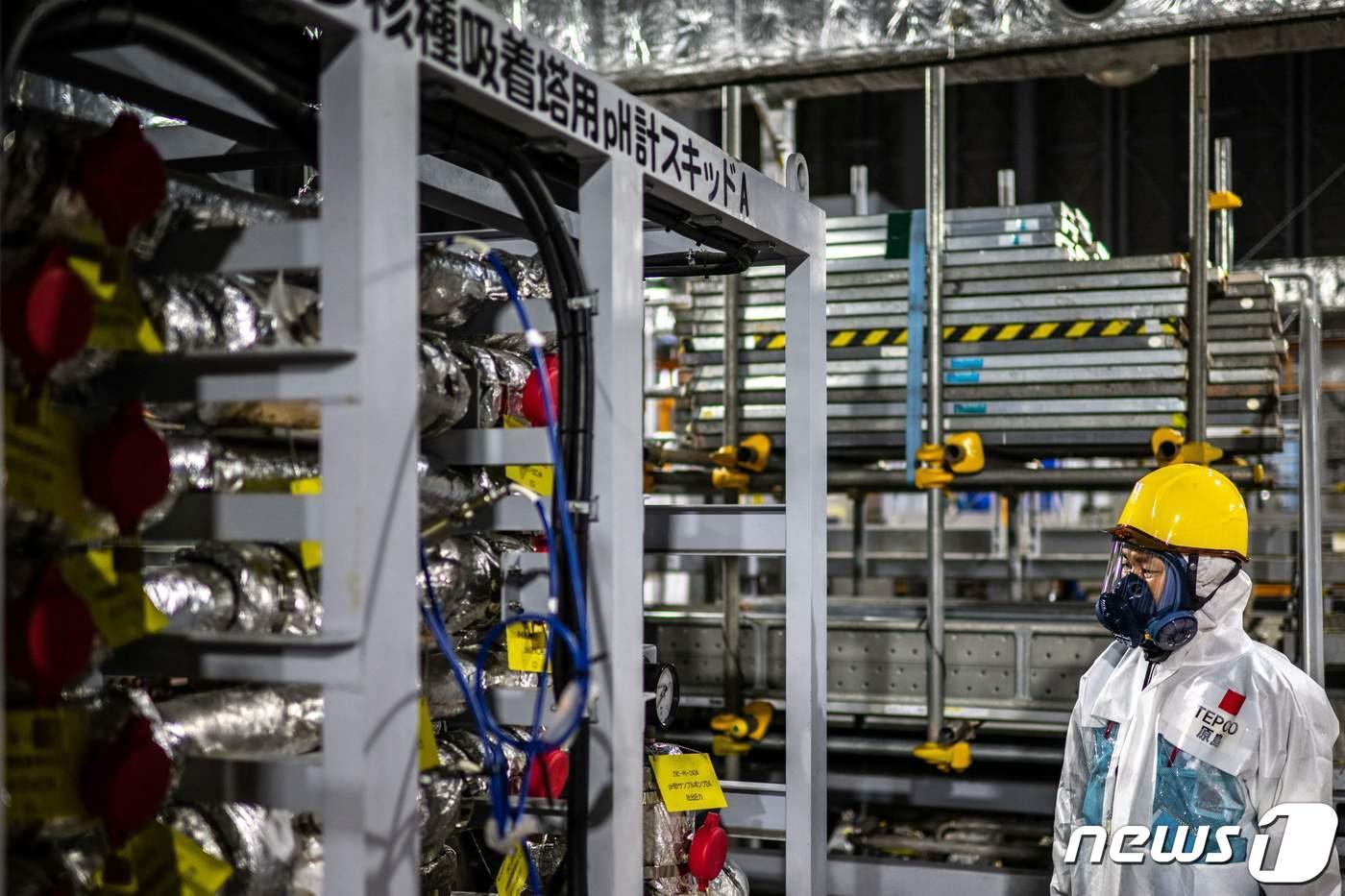 본문 이미지 - 일본 후쿠시마 제1 원자력 발전소의 다카하라 겐이치 위험 소통관이 다핵종 제거설비(ALPS)를 살펴보고 있다. ⓒ AFP=뉴스1 ⓒ News1 권진영 기자