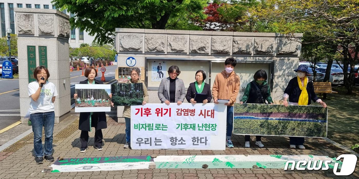 제주녹색당과 시민사회단체인 '비자림로를 지키기 위해 뭐라도 하려는 시민모임' 관계자들이 26일 오전 제주지방법원 앞에서 기자회견을 하고 있다.2023.4.26./뉴스1