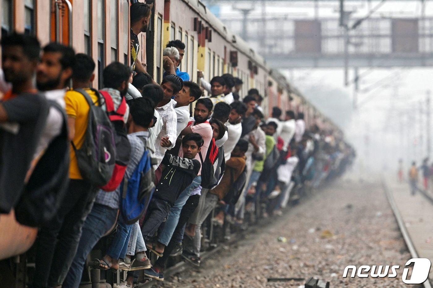 본문 이미지 - 인도 우타르프라데시주 가지아바드에 있는 로니의 기차역에서 승객들이 열차에 매달려 있는 모습. ⓒ AFP=뉴스1