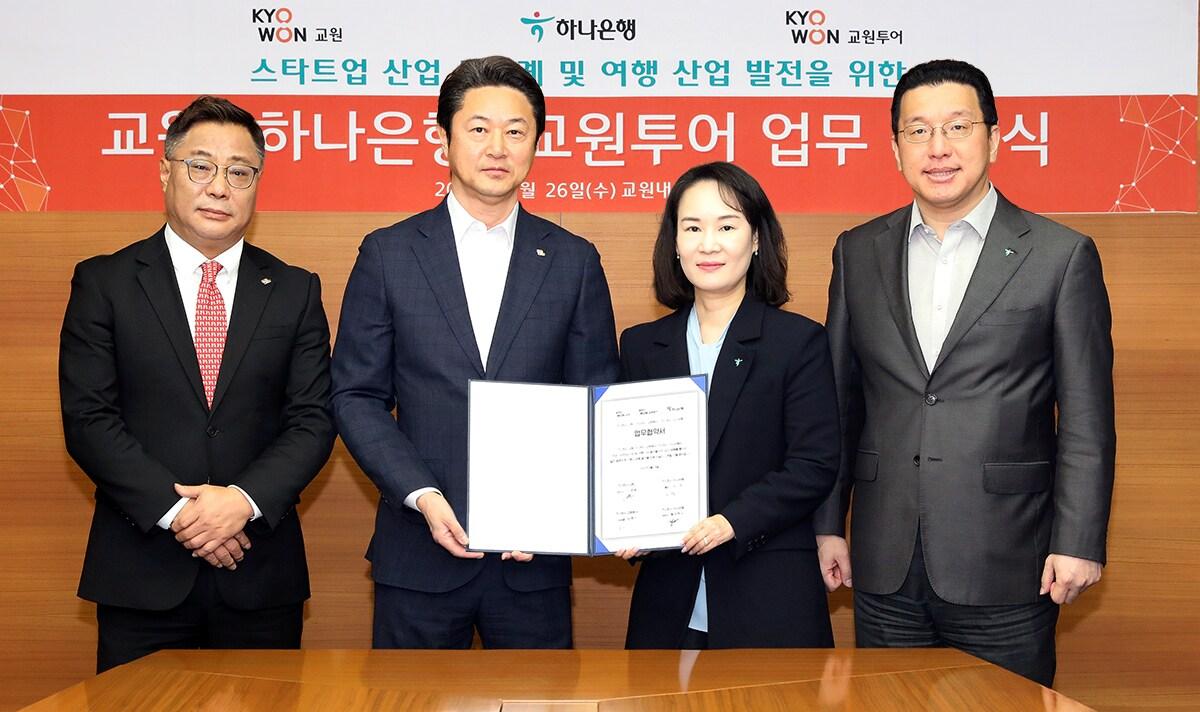 본문 이미지 - 하나은행은 지난 26일 오후 서울 중구 교원그룹 본사에서 교원그룹과 스타트업 생태계 활성화 지원을 위한 업무 협력 및 여행과 금융의 융합 비즈니스 공동 추진을 위한 전략적 업무협약(MOU)을 체결했다고 밝혔다. 김소정 하나은행 디지털그룹장(사진 왼쪽에서 세번째), 황보현우 하나은행 데이터&제휴투자본부장(사진 왼쪽에서 네번째), 신영욱 교원 대표이사(사진 왼쪽에서 두번째), 김명진 교원투어 사업대표(사진 왼쪽에서 첫번째)가 기념촬영을 하고 있다.(하나은행 제공)