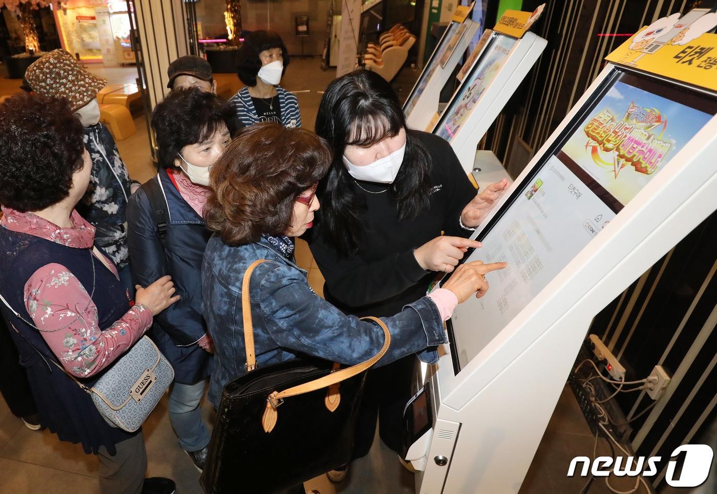 본문 이미지 - 27일 오전 대구의 한 영화관에서 현장체험활동을 나온 대구내일학교 늦깎이 학습자들이 무인티켓판매기(키오스크) 사용법을 배운 뒤 직접 영화 티켓을 발권하고 있다.2023.4.27/뉴스1 ⓒ News1 공정식 기자