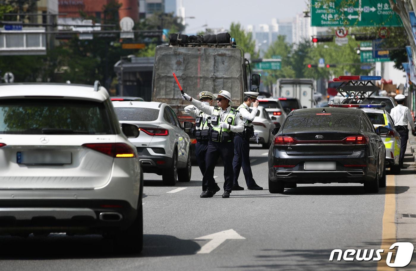 본문 이미지 - 27일 서울 송파구 방이삼거리에서 경찰들이 우회전 시 일시정지 의무 위반 차량 단속을 하고 있다. 우회전 시 전방 차량 신호가 빨간불일 땐 보행자 유무와 무관하게 정지선이나 횡단보도 앞에서 일시 정지한 후 우회전해야 하며, 이를 어기면 도로교통법에 따라 승합차 7만 원, 승용차 6만 원, 이륜차 4만 원의 범칙금과 벌점 15점이 부과된다. 2023.4.27/뉴스1 ⓒ News1 김민지 기자
