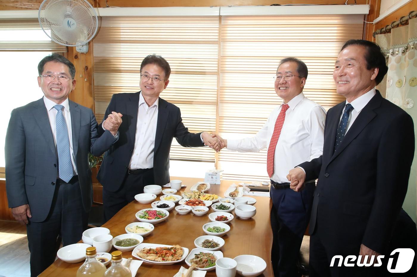 본문 이미지 - 김진열 군위군수, 이철우 경북도지사, 홍준표 대구시장, 김주수 의성군수(왼쪽부터)가 지난 4월 28일 오전 경북 군위군의 한 한정식집에서 열린 대구경북신공항 성공적인 건설을 위한 화합 간담회에 참석해 함께 손잡고 환하게 웃고 있다. (사진은 기사 내용과 무관함) 2023.4.28/뉴스1 ⓒ News1 공정식 기자