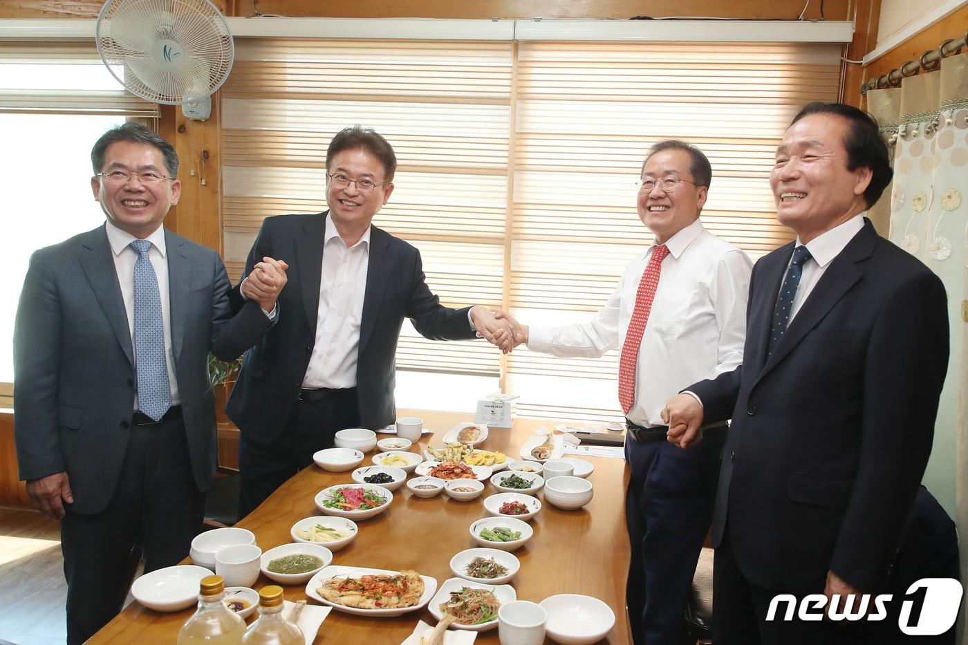 본문 이미지 - 김진열 군위군수, 이철우 경북도지사, 홍준표 대구시장, 김주수 의성군수(왼쪽부터)가 28일 오전 경북 군위군의 한 한정식집에서 열린 대구경북신공항 성공적인 건설을 위한 화합 간담회에 참석해 함께 손잡고 환하게 웃고 있다. 2023.4.28/뉴스1 ⓒ News1 공정식 기자