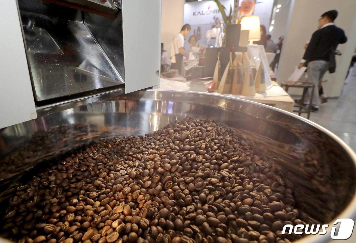 본문 이미지 - 서울 강남구 코엑스에서 열린 서울 커피엑스포에 참가한 업체의 로스터기에 막 볶아진 커피콩이 전시돼 있다.ⓒ 뉴스1 장수영 기자
