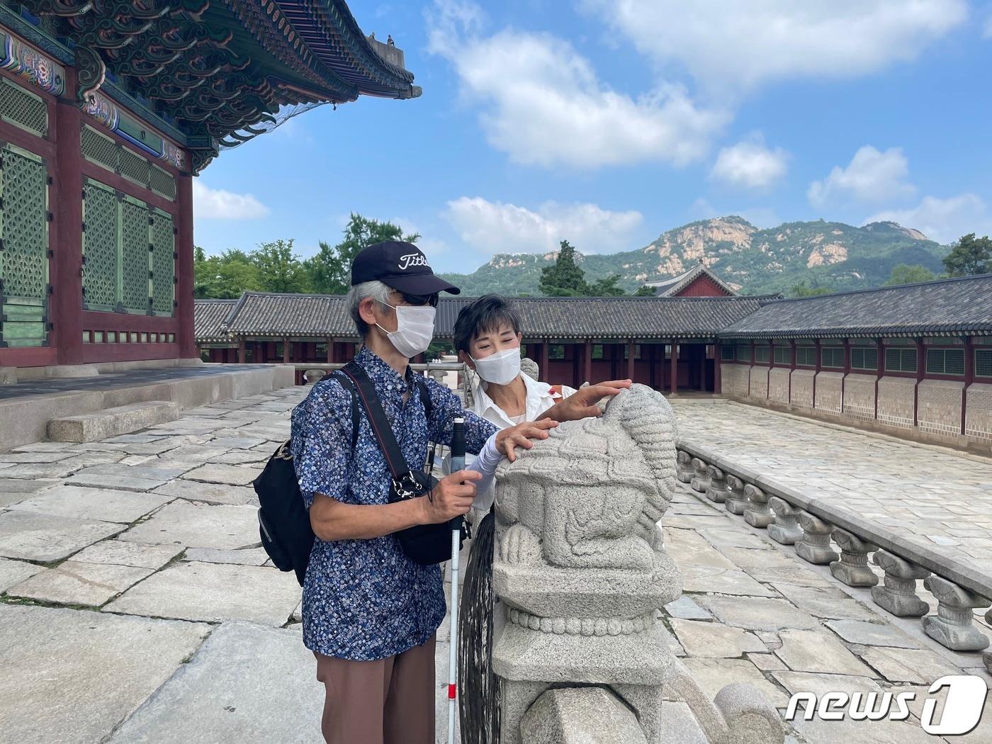 본문 이미지 - 서울관광재단 현장영상해설사의 해설을 들으며 해치를 만져보는 시각장애인 관람객(서울관광재단 제공)