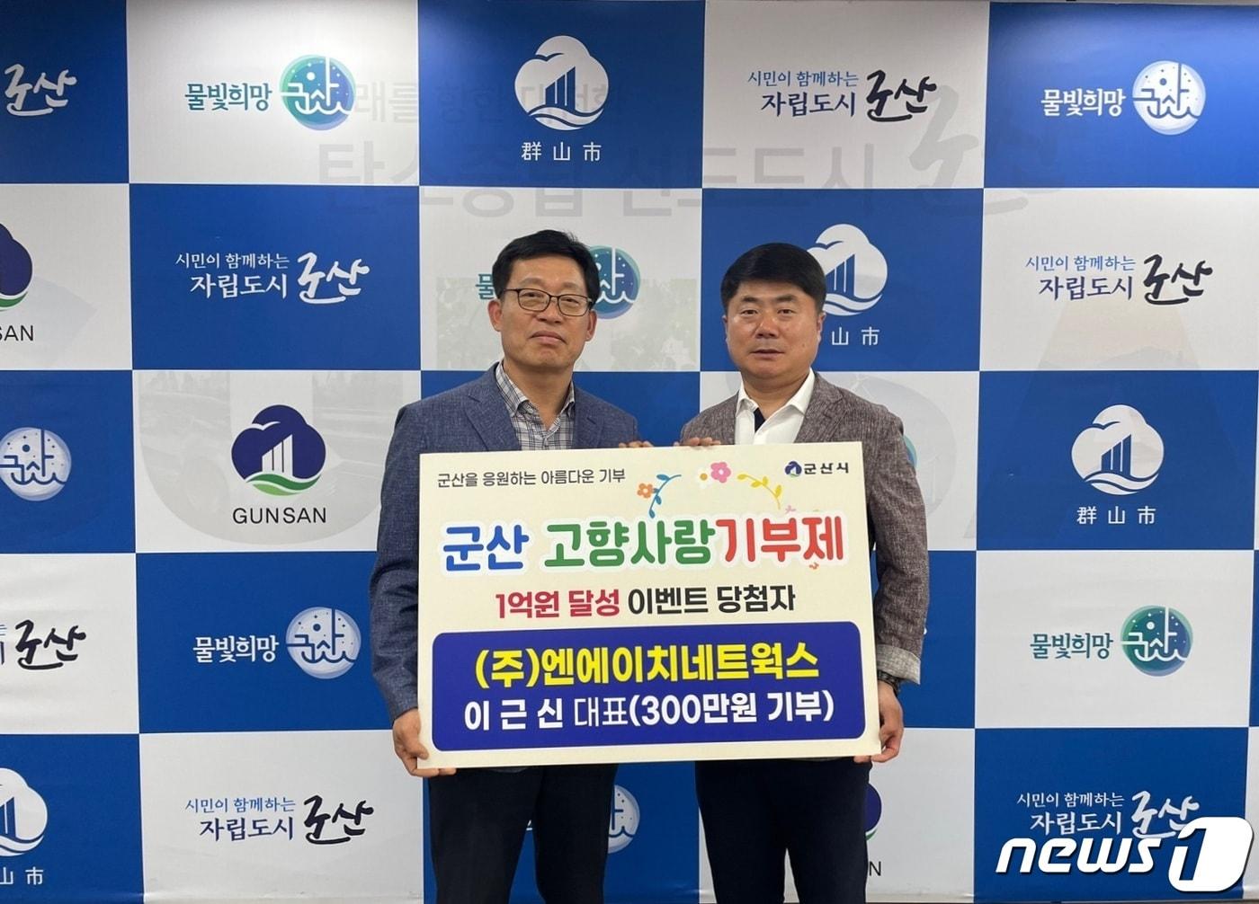 본문 이미지 - 전북 군산시는 1억원 달성 기부자인 이근신 (주)엔에이치네트웍스 대표(사진 오른쪽)에게 안창호 자치행정국장이 시상금을 전달하고 있다.(군산시제공) 2023.5.11/뉴스1