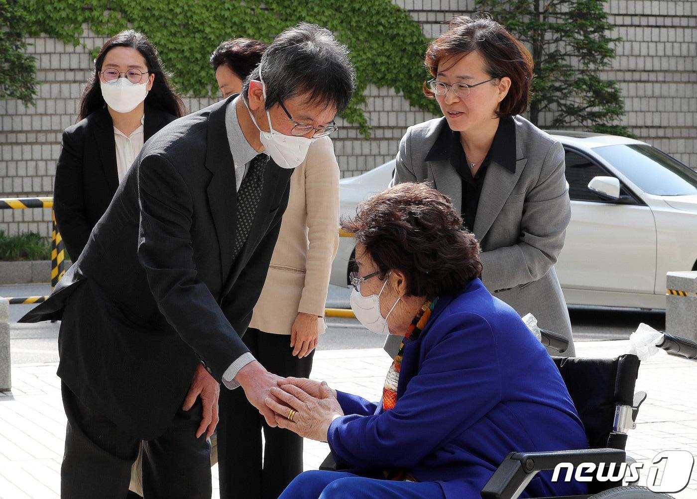 본문 이미지 - 이용수 할머니와 일본인 야마모토 세이타 변호사가 11일 오후 서초구 서울고등법원에서 열린 위안부 피해 할머니 일본 정부 상대 손해배상 소송 공판에 출석하며 손을 잡고 인사를 나누고 있다. 원고측 증인으로 출석한 야마모토 변호사는 일본에서 인권변호사로 활동하며 30년 넘게 위안부 피해자들을 대변해왔다. 2023.5.11/뉴스1 ⓒ News1 박세연 기자