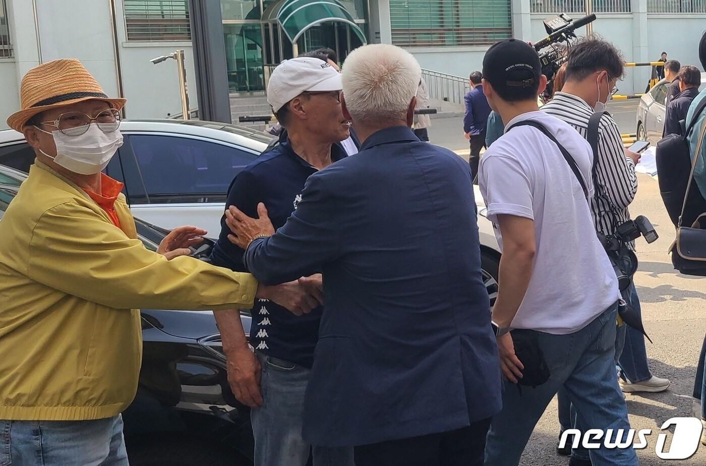 본문 이미지 - 50년 만에 무죄 선고 받은 납북귀환어부 피해자들이 법정 밖에 나와 부둥켜 안고 있다. 2023.5.12/뉴스1 이종재기자
