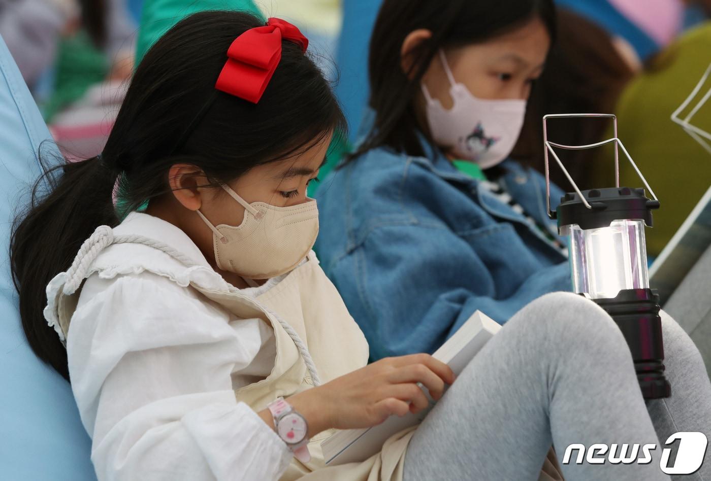 본문 이미지 - 서울 광화문광장에 마련된 야외도서관 '광화문 책마당'을 찾은 어린이가 책을 읽는 모습. (뉴스1DB) ⓒ News1 구윤성 기자