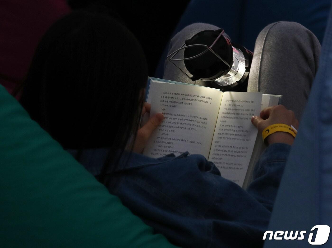 본문 이미지 - 서울 광화문광장에 마련된 야외도서관 '광화문 책마당'을 찾은 시민이 책을 읽고 있다. /뉴스1 ⓒ News1 구윤성 기자