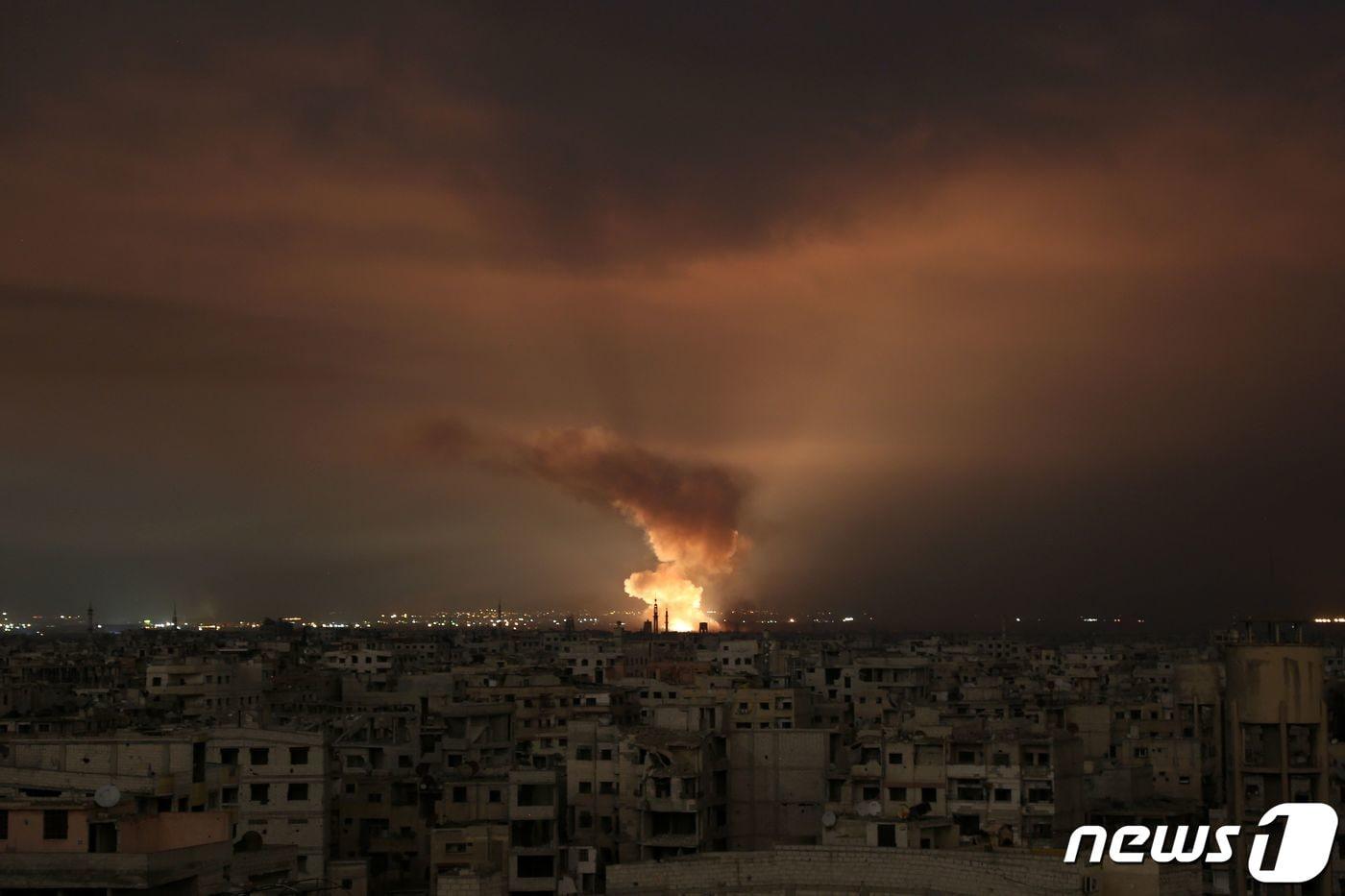 23일(현지시간) 시리아 수도 다마스쿠스 외곽 구타 동부 지역에서 거대한 화염이 밤하늘에 솟아오르고 있다. 2018.2.23 ⓒ AFP=뉴스1 ⓒ News1 정윤미 기자