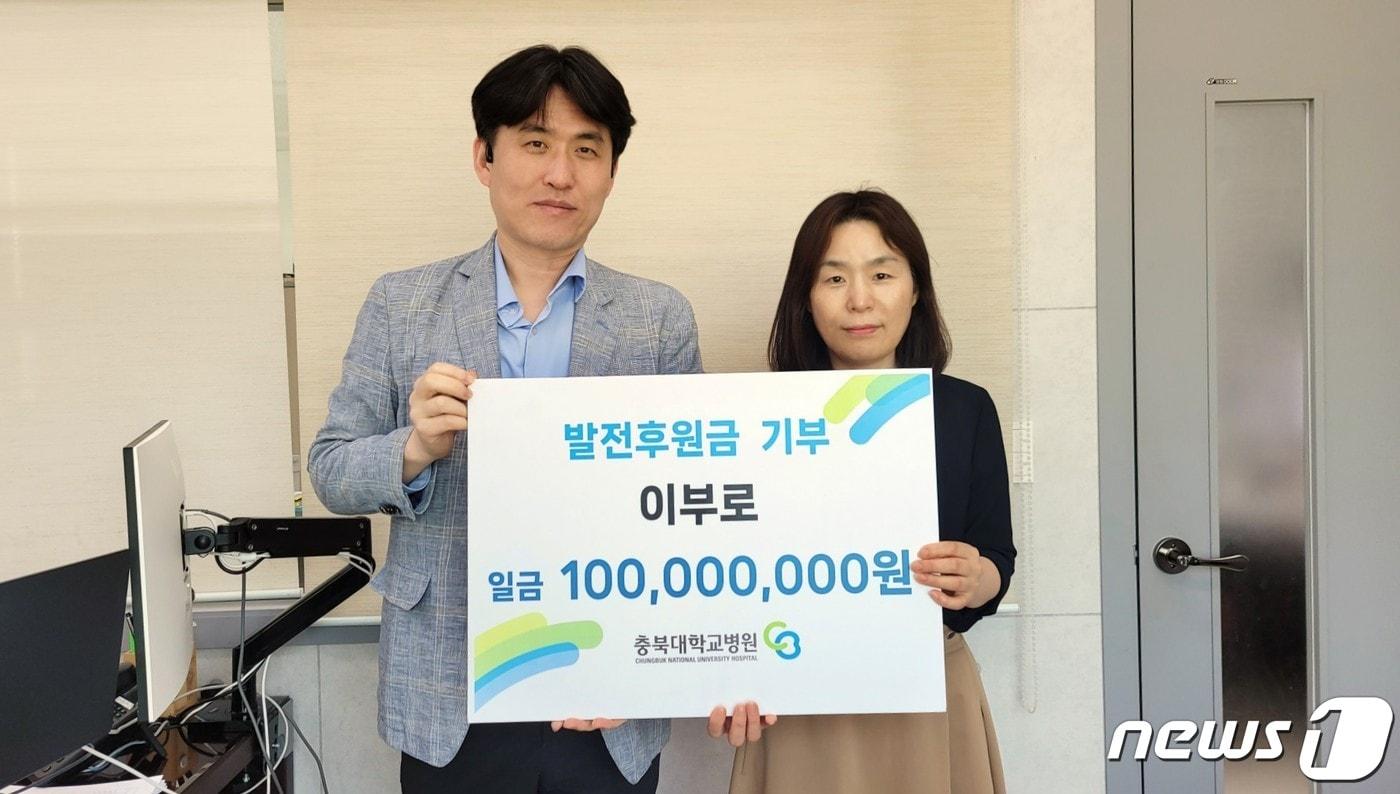본문 이미지 - 고 이부로씨 아들 이중선씨(왼쪽)가 충북대학교병원 발전후원회 윤옥희 담당에게 암병원건립기금 1억원을 기탁한 뒤 기념촬영을 하고 있다.(충북대병원 제공)/ 뉴스1