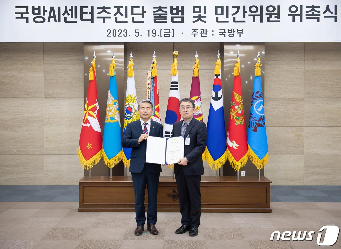 본문 이미지 - 이종섭 전 국방부 장관이 19일 오전 서울 국방부 청사에서 열린 '국방AI센터' 추진단 출범 및 민간위원 위촉식에서 이승섭 카이스트 교수에게 '국방AI센터 공동추진단장' 위촉장을 수여하고 있다. (국방부 제공) 2023.5.19/뉴스1