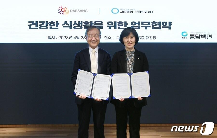 본문 이미지 - 지난 28일 대상 본사에서 열린 '건강한 식생활을 위한 업무협약식’에서 박은영 대상 식품사업총괄 중역(오른쪽)과 김광원 한국당뇨협회의 회장(왼쪽)이 협약서를 들고 기념촬영을 하고 있다.(대상 제공)