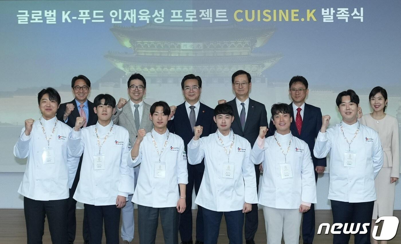 본문 이미지 - 2일 서울 필동 CJ인재원에서 열린 Cuisine. K 발족식에서 CJ제일제당 주요 경영진, 농림축산식품부 장관 및 관계자, 국가대표조리팀 대표 선수들이 함께 기념사진을 촬영하고 있다. (왼쪽 위쪽부터 박민석 CJ제일제당 식품부문 대표, 이선호 식품성장추진실장, 정황근 농식품부 장관, 최은석 CJ제일제당 대표이사, 양주필 농식품부 식품산업정책관, 문지인 식품외식산업과장/CJ제일제당 제공)