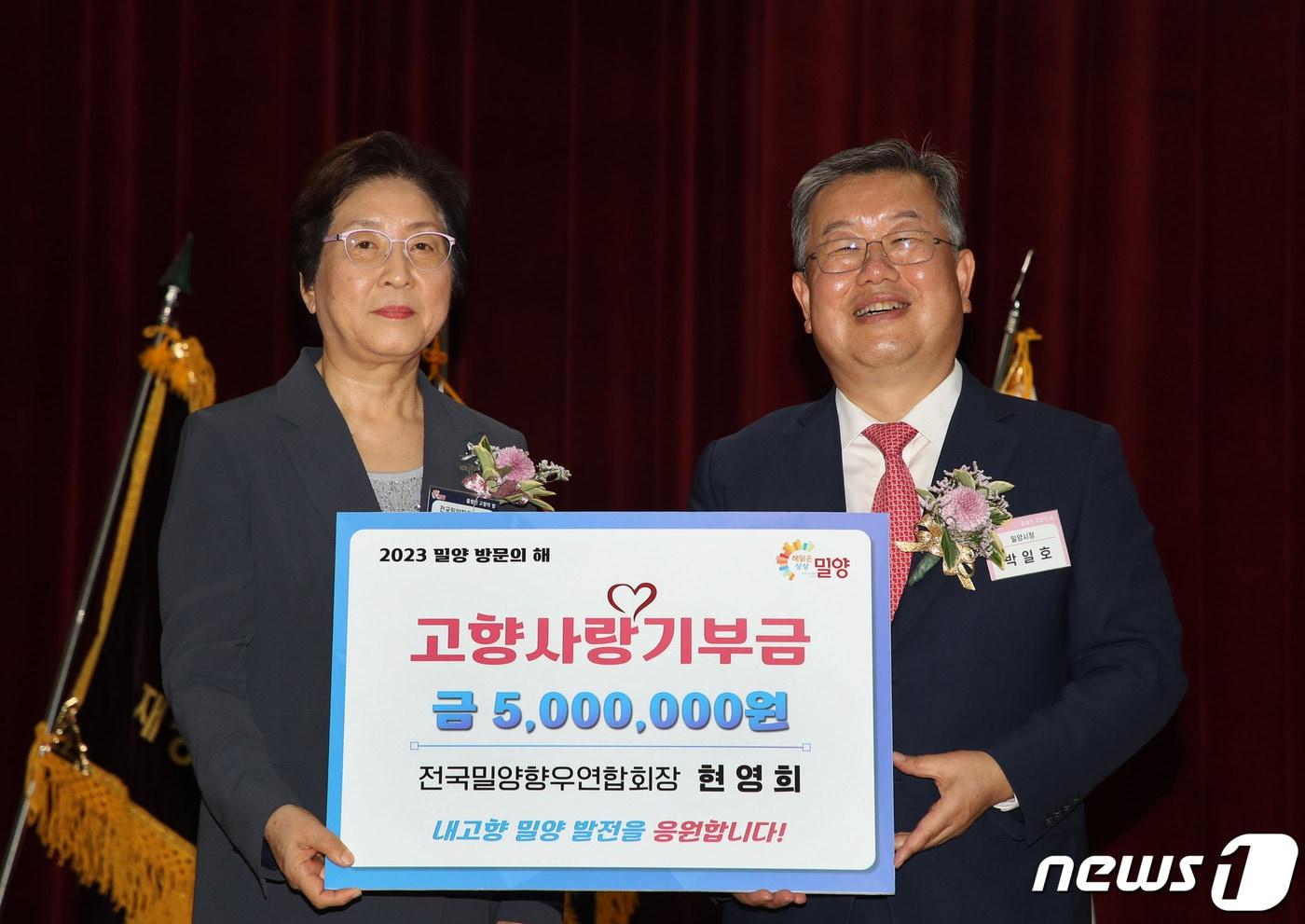 현영희 전국밀양향우연합회장이 밀양시에 고향사랑기부금을 전달하고 박일호 밀양시장과 기념촬영을 하고 있다.(밀양시 제공)