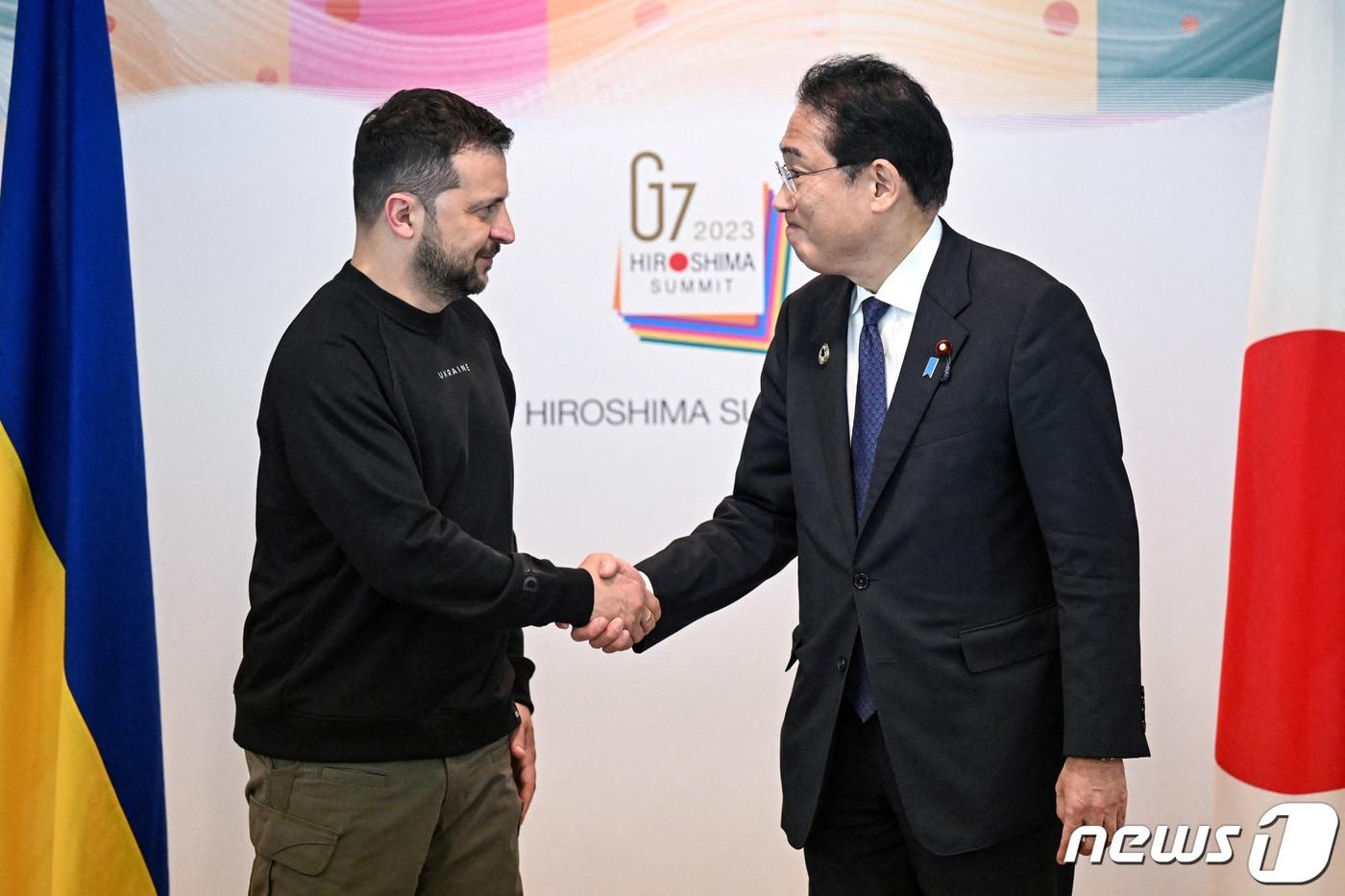 본문 이미지 - 기시다 후미오 일본 총리와 볼로디미르 젤렌스키 우크라이나 대통령이 21일 (현지시간) 일본 히로시마에서 열린 G7 정상회의를 마친 뒤 악수를 하고 있다. 2023.05.21 ⓒ 로이터=뉴스1 ⓒ News1 우동명 기자