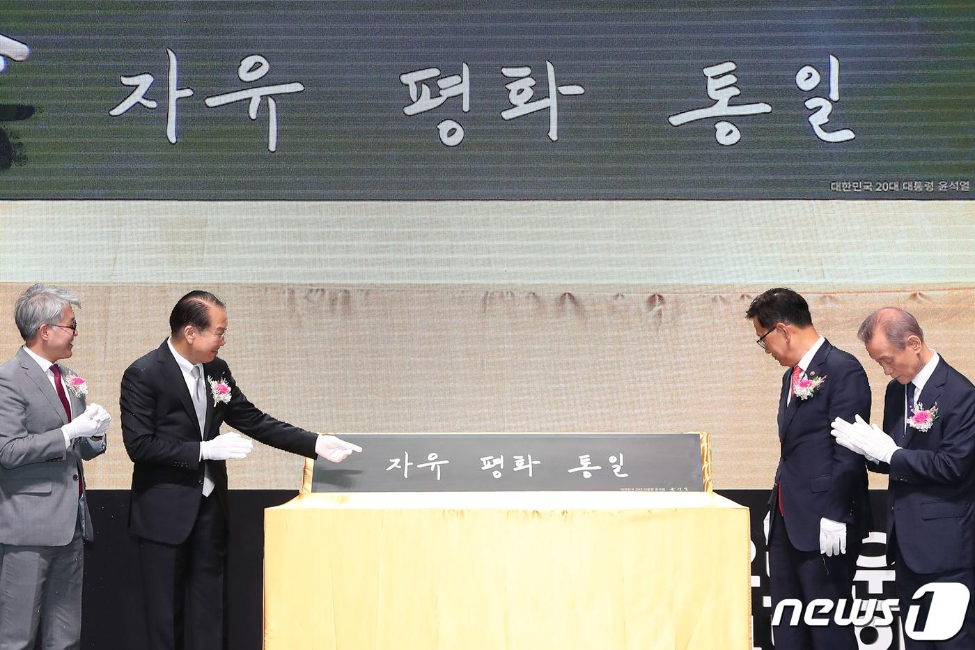 본문 이미지 - 지난 5월 권영세 통일부 장관(왼쪽 두 번째)과 이인배 국립통일교육원장을 비롯한 참석자들이 '제11회 통일교육주간 기념식'에서 윤석열 대통령의 휘호 '자유·평화·통일'을 공개하고 있다. 2023.5.22/뉴스1 ⓒ News1 민경석 기자