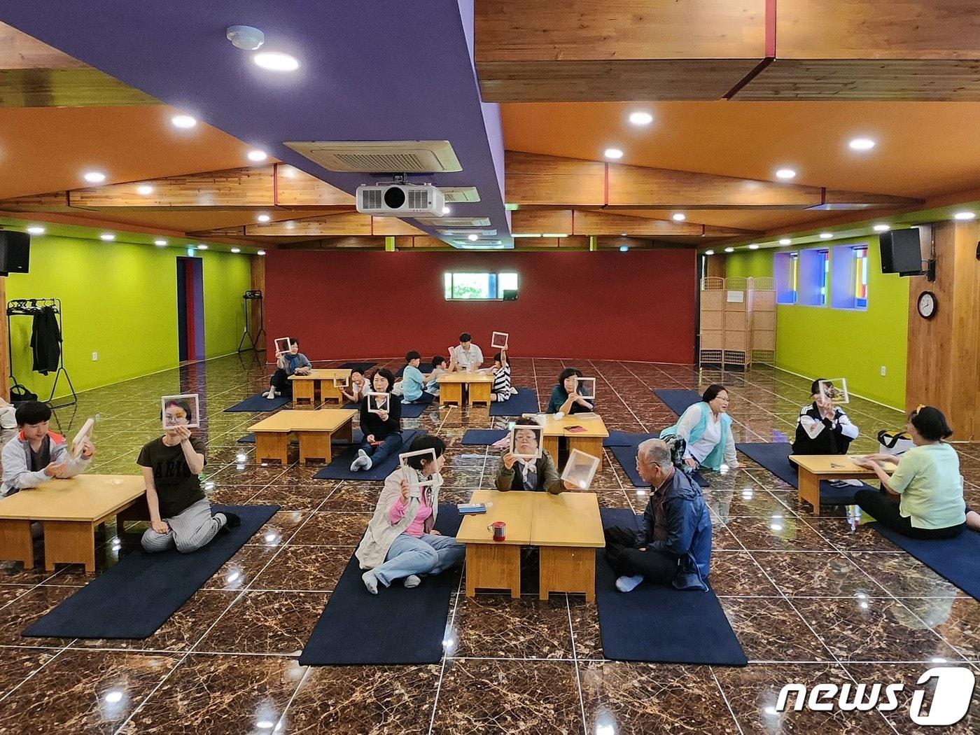 본문 이미지 -  참가자들이 국립산림치유원 명상센터에서 반려동물과 추억을 간직하는 나무액자를 만들어 들어 보이고 있다.  (산림청 한국산림복지진흥원 제공)/뉴스1