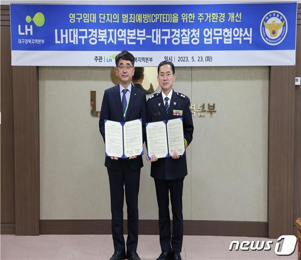 본문 이미지 - 23일 신광호 LH 대구경북지역본부장(왼쪽)과 김수영 대구경찰청장이 영구임대 단지 범죄예방(CPTED)을 위한 주거환경 개선 업무협약을 체결하고 협약서를 펼쳐 보이고 있다.(LH 대구경북지역본부 제공)
