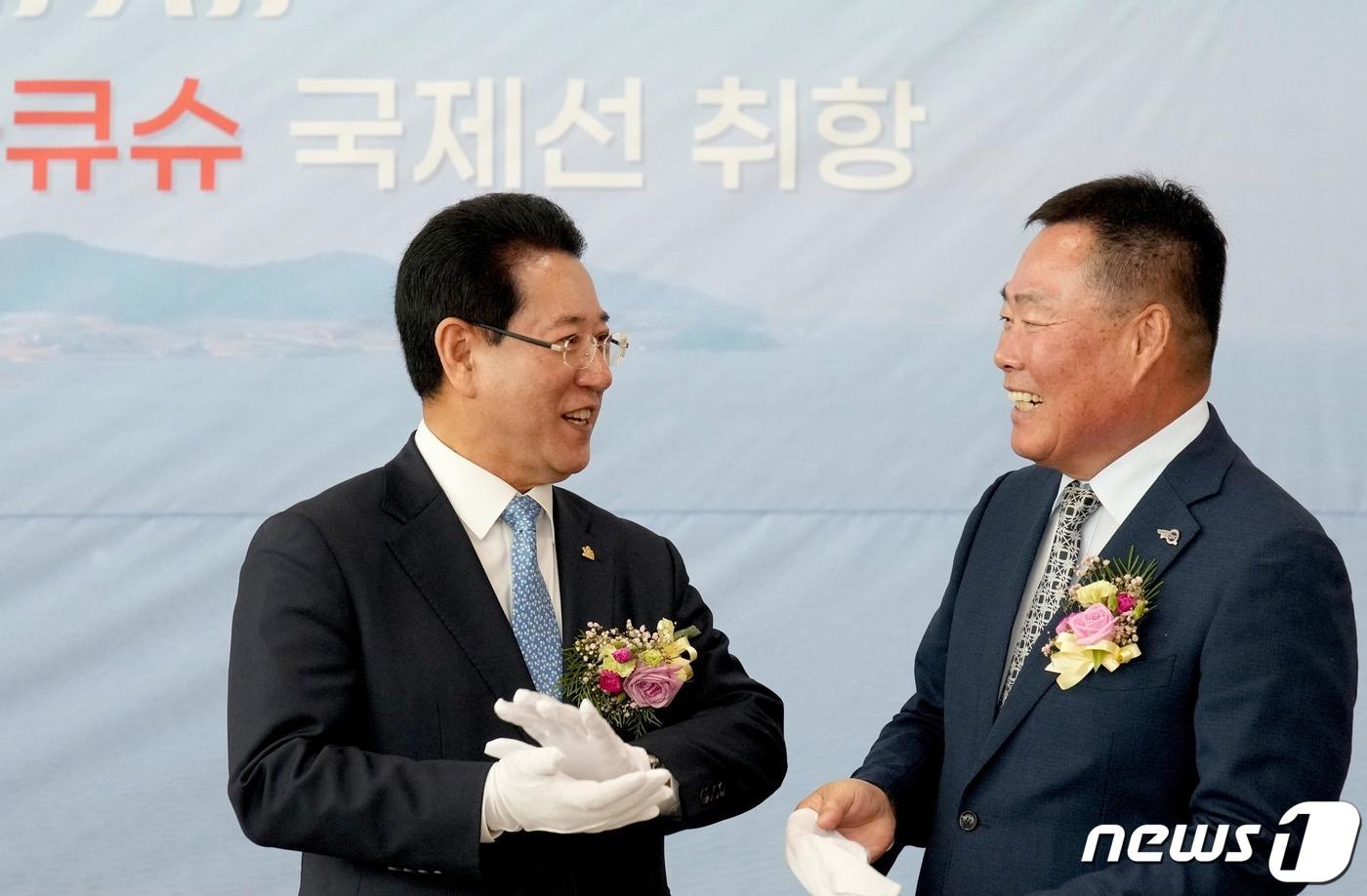 본문 이미지 - 김영록 전라남도지사가 24일 오전 무안국제공항 여객청사에서 열린 하이에어 국제선(무안~키타큐슈) 운항 취항식 행사에서 김산 무안군수와 손을 이야기를 나누고 있다.(전남도 제공) 2023.5.24/뉴스1 