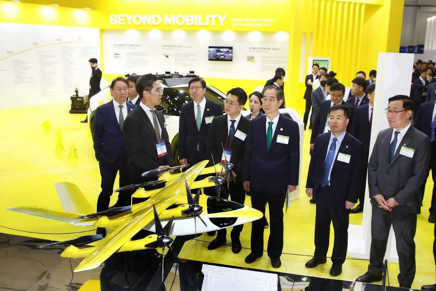 카카오모빌리티 류긍선 대표(가운데), 장성욱 부사장(왼쪽)이 부스를 방문한 한덕수 국무총리(오른쪽)에게 UAM 기체를 설명하고 있다.카카오모빌리티 제공.