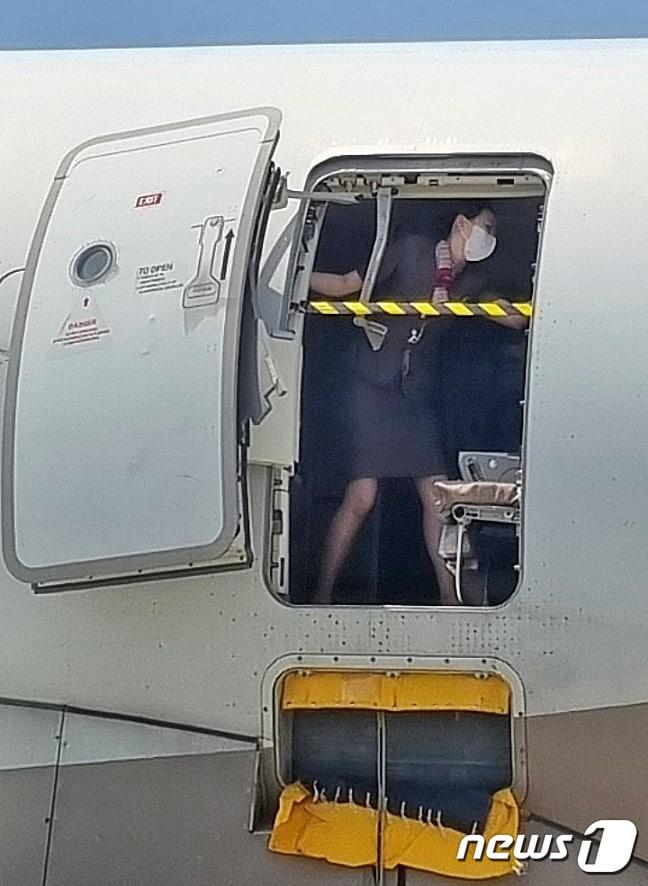 본문 이미지 - 2023년 5월 26일 제주에서 출발해 대구로 향하던 아시아나항공기에 탑승한 30대 남성 A씨가 대구공항 상공에서 비상문을 강제로 개방해 승객들을 공포에 떨게 한 가운데 승무원이 비상문을 온몸으로 막고 있다.&#40;독자 제공&#41; 2023.5.28/뉴스1 ⓒ News1 공정식 기자