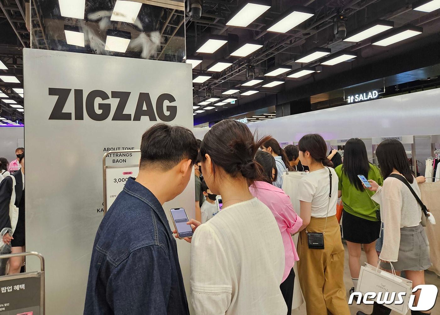본문 이미지 - 지난 28일 서울 영등포구 더현대 서울의 지그재그 팝업 스토어를 찾은 고객이 QR코드 촬영을 하고 있다. (카카오스타일 제공) 2023.5.29/뉴스1