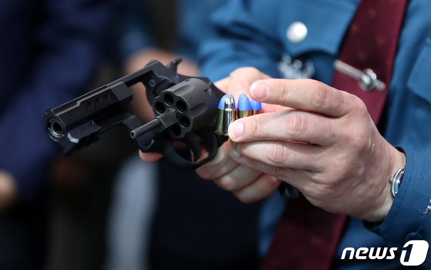 윤희근 경찰청장이 3일 서울 서대문구 미근동 경찰청 1층 로비와 주차장에서 열린 과학치안 연구개발(R&D) 성과 전시회에서 저위험 권총을 들어보고 있다. 2023.5.3/뉴스1 ⓒ News1 박지혜 기자