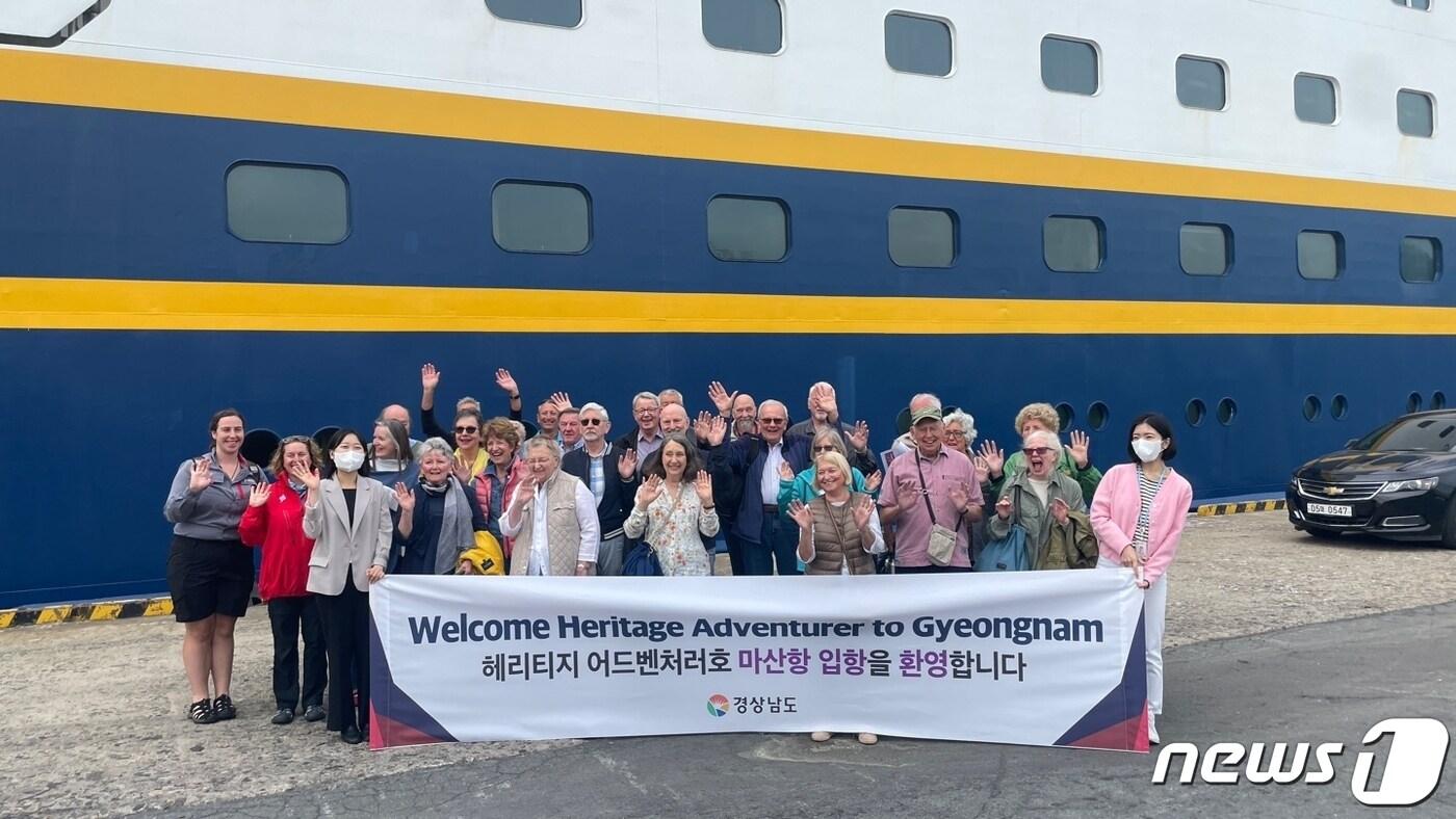 본문 이미지 - 3일 오전 7시 마산항 3부두로 입항한 영국 헤리티지 어드벤처러호 승객들이 하선 후 기념사진을 찍고 있다.(경남도 제공)