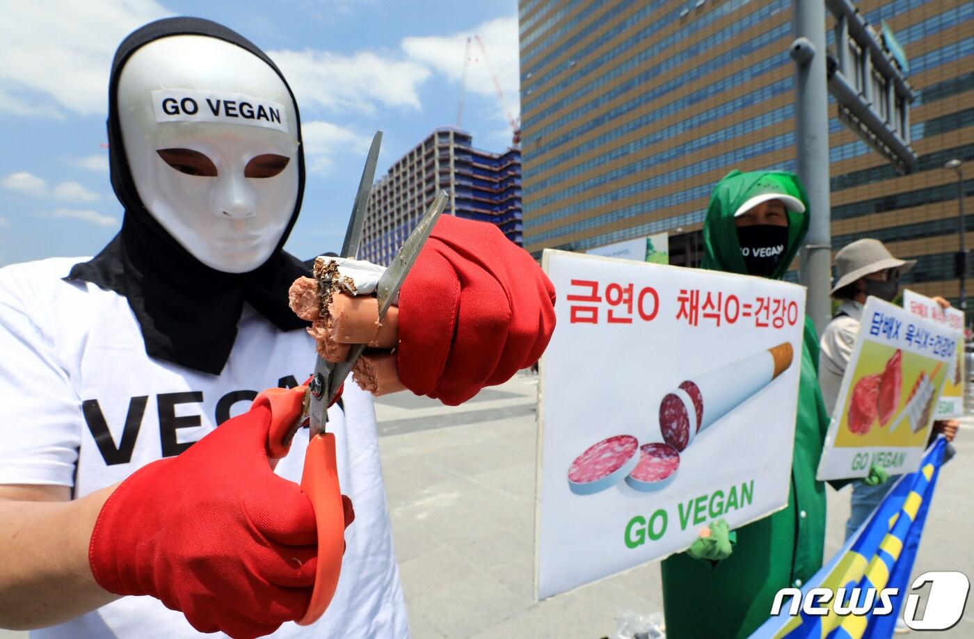 서울 광화문 광장에서 가진 세계 금연의 날을 맞아 금연과 채식으로 건강 촉구 기자회견에서 소시지와 담배를 가위로 자르는 퍼포먼스를 펼치고 있다. 이들은 1군 발암물질인 담배와 함께 세계보건기구 산하 국제암연구소가 햄, 소시지, 베이컨 등 가공육은 1군, 적색육은 2군 발암물질로 분류했다며, 심장병, 암, 당뇨병, 고혈압 등으로 인한 사망자의 80%가량이 육식으로 인한 사망인 것으로 추정해 금연과 채식으로 건강한 사회를 만들 것을 촉구했다. 2023.5.31/뉴스1 ⓒ News1 박정호 기자