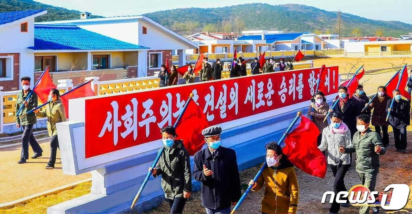 본문 이미지 - (평양 노동신문=뉴스1) = 북한 노동당 기관지 노동신문이 7일 "봄철 영농작업으로 세차게 약동하는 사회주의 전야"를 선전했다. 황해남도 과일군 주민들이 '사회주의 농촌 건설의 새로운 승리를 향하여'란 문구 앞을 지나고 있다. [국내에서만 사용가능. 재배포 금지. DB 금지. For Use Only in the Republic of Korea. Redistribution Prohibited] rodongphoto@news1.kr