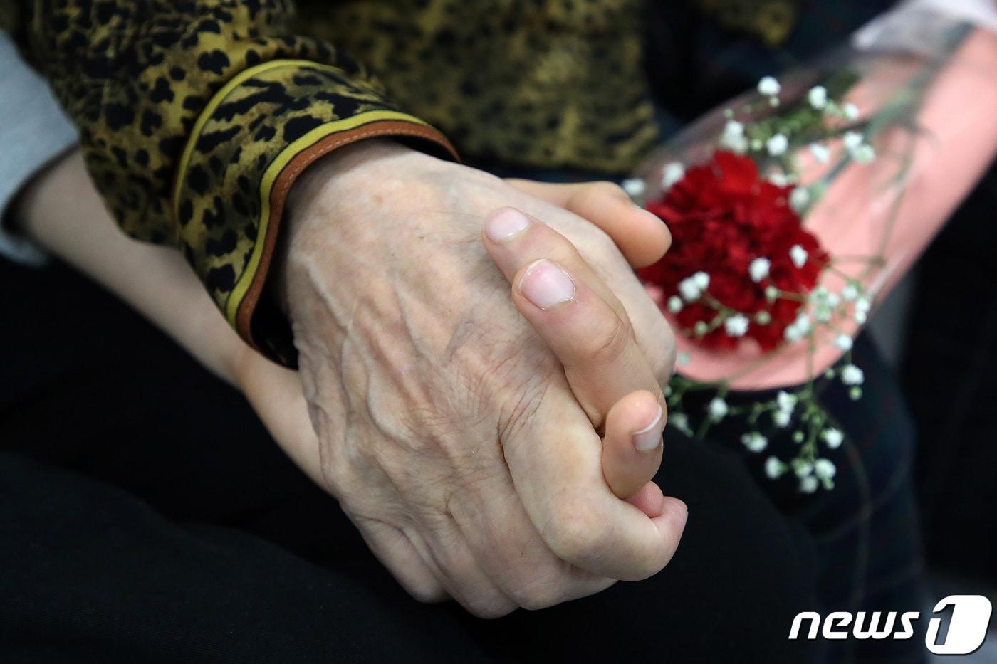 본문 이미지 - 경북 경산시 중방동의 한 요양원에서 면회를 온 가족이 어머니께 카네이션을 선물한 뒤 손을 잡고 있다. 2023.5.7 ⓒ 뉴스1 공정식 기자