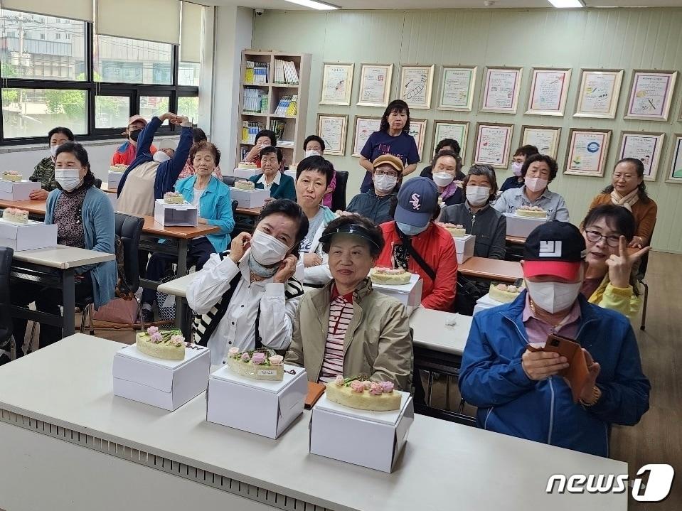 본문 이미지 -  4일 충북 충주열린학교 수강생들이 어버이날을 맞아 손수 만든 떡케이크를 자랑하고 있다.(충주열린학교 제공)2023.5.8/뉴스1