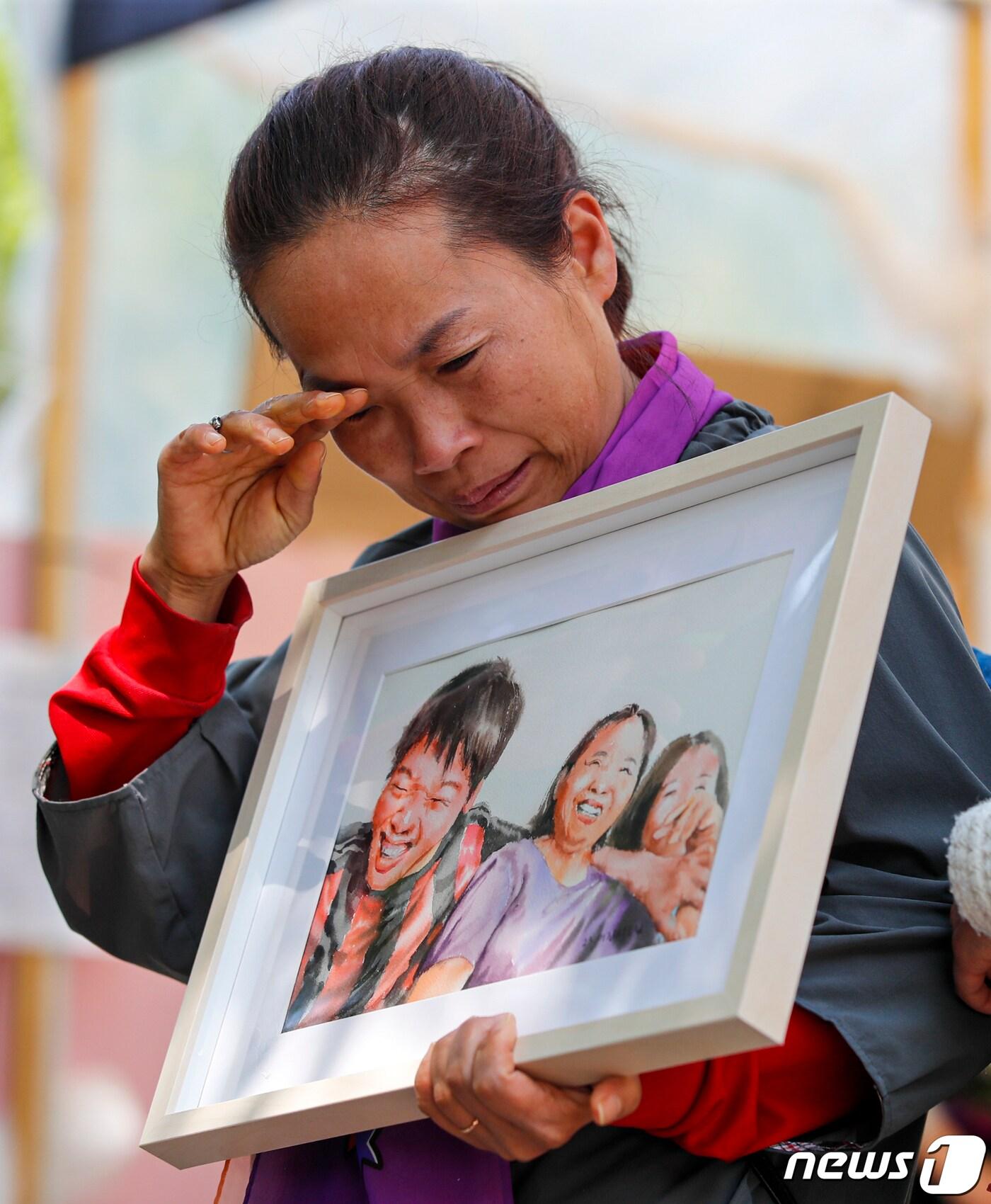 본문 이미지 - 10.29 이태원 참사 유가족이 8일 서울 중구 서울광장 분향소에서 열린 '이태원 참사 200일 200시간 집중추모행동 주간 선포 기자회견'에서 촛불갤러리로부터 받은 가족 그림을 품에 안고 있다.  2023.5.8/뉴스1 ⓒ News1 김도우 기자