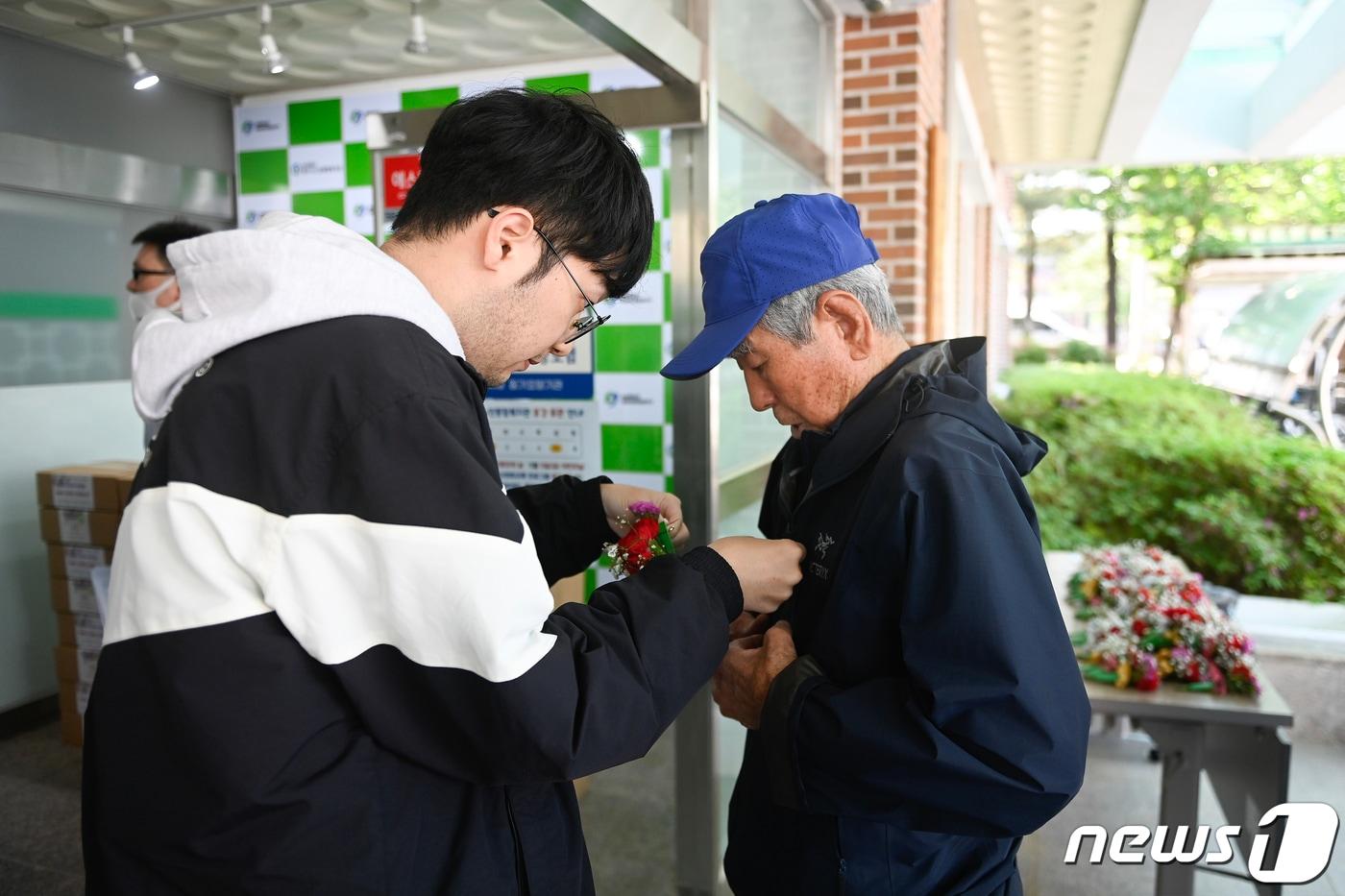 본문 이미지 - 제51회 어버이날 행사가 8일 원주시종합복지관에서 200여 명이 모인 가운데 펼쳐진 가운데 행사에 앞서 한 어르신이 참석 전 옷에 카네이션을 부착하고 있다. (원주시 제공) 2023.5.8/뉴스1
