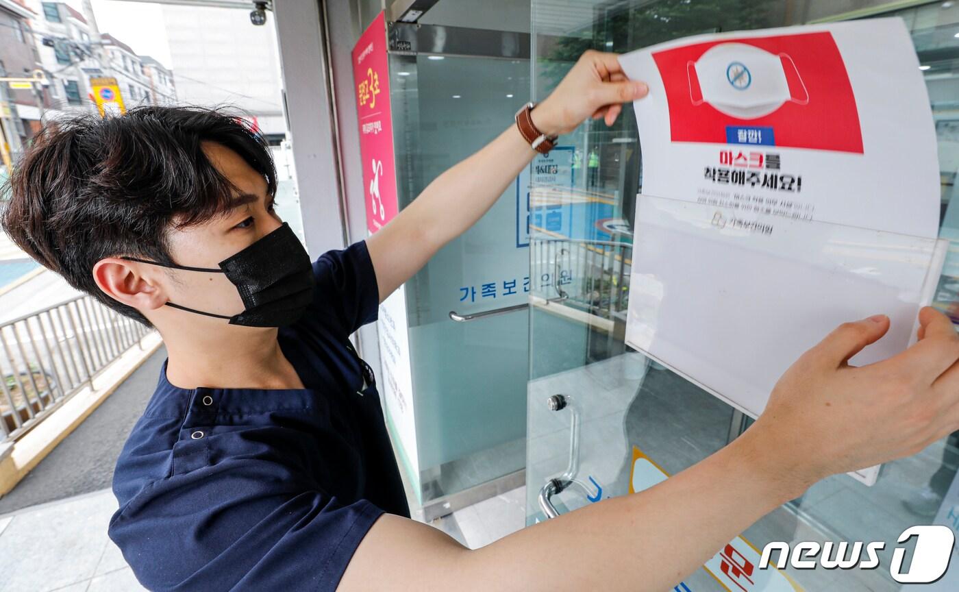 본문 이미지 - 코로나19 위기 경보 수준이 '심각'에서 '경계'로 하향된 1일 서울 광진구 인구보건복지협회 가족보건의원에서 직원이 마스크 착용 안내문을 떼고 있다.  2023.6.1/뉴스1 ⓒ News1 김도우 기자