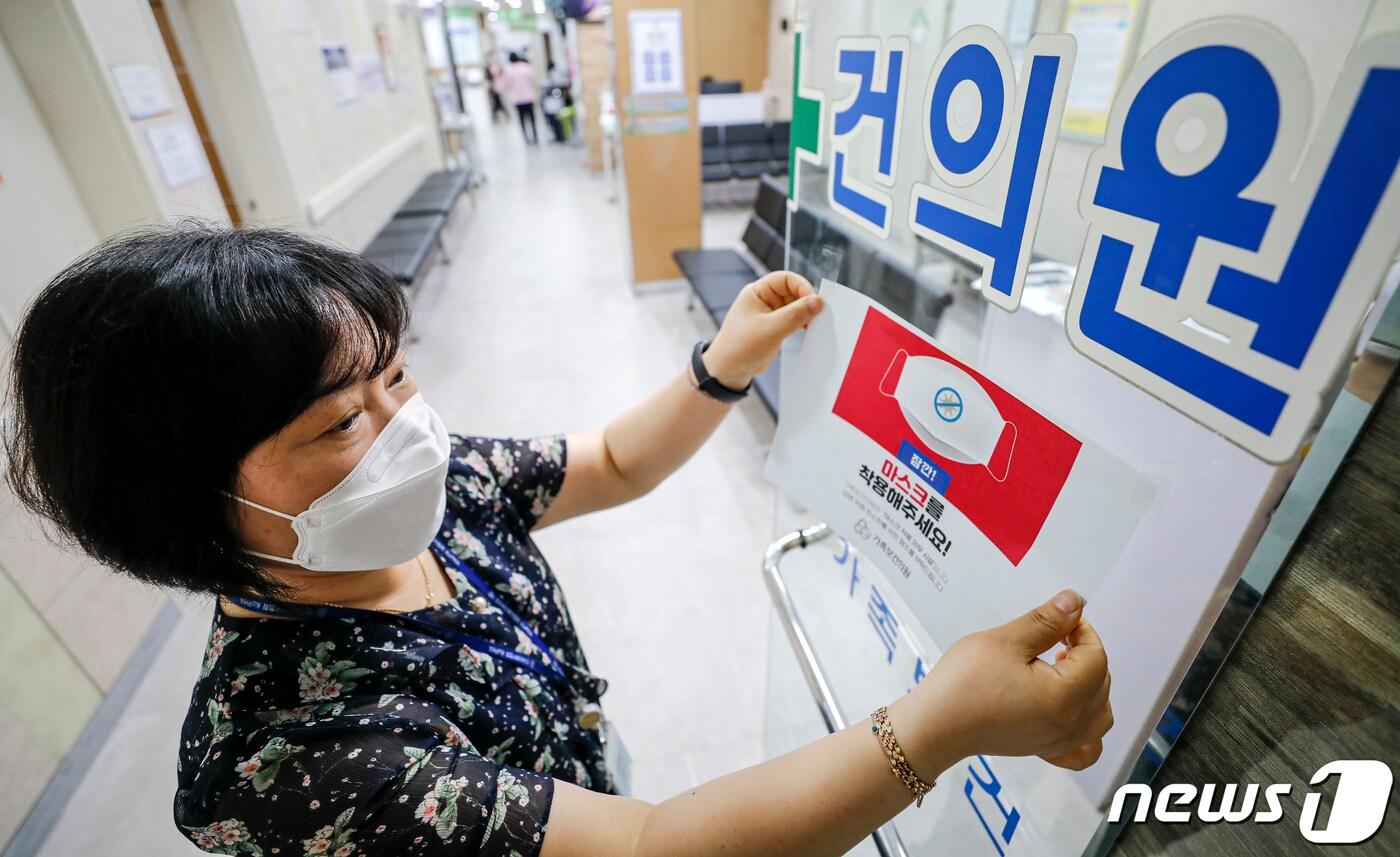 본문 이미지 - 코로나19 위기 경보 수준이 '심각'에서 '경계'로 하향 된 1일 서울 광진구 인구보건복지협회 가족보건의원에서 직원이 마스크 착용 안내문을 떼고 있다.2023.6.1/뉴스1 ⓒ News1 김도우 기자