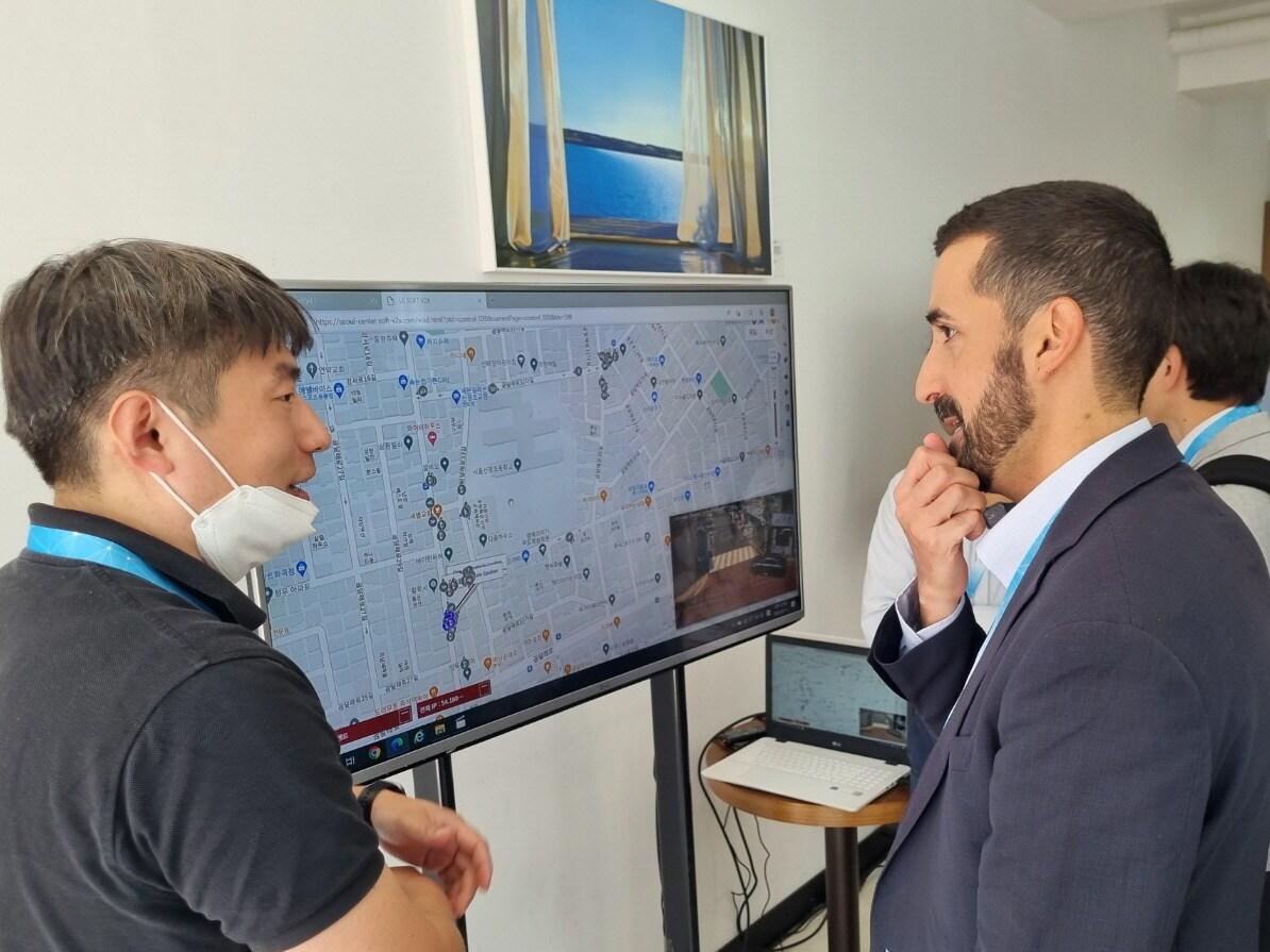 본문 이미지 - LG전자 관계자(왼쪽)가 글로벌 차량통신 연합체 5GAA(5G Automotive Association) 관계자에게 자율주행 기술 기반 교통안전 솔루션 Soft V2X 앱을 소개하고 있다. (LG전자 제공)