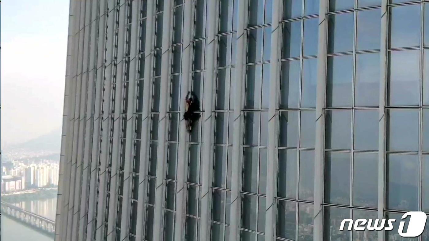 지난 12일 오전 서울 송파구 잠실 롯데월드 타워에서 조지 킹 톰슨씨가 맨손으로 등반하고 있다.  (송파소방서 제공) 2023.6.12/뉴스1